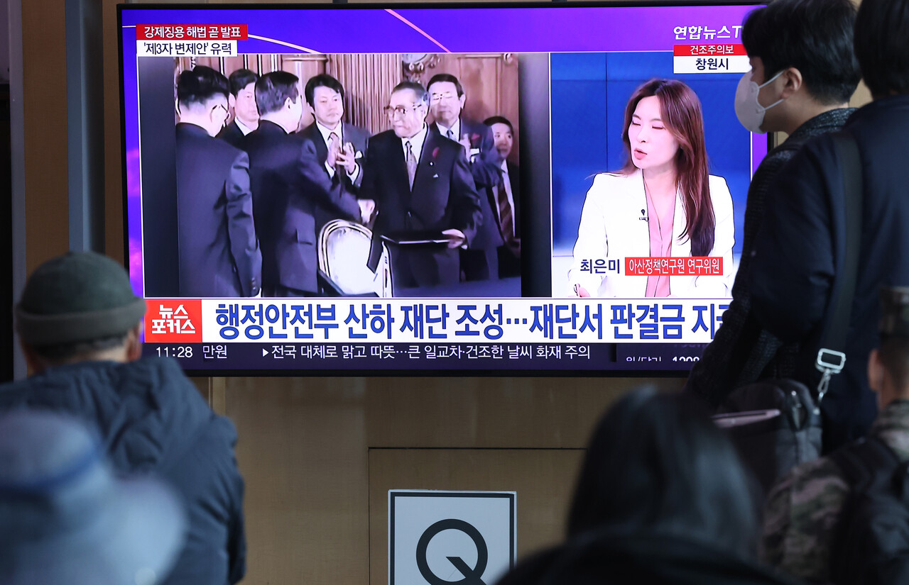 정부가 강제징용 배상 문제 해법안을 공식 발표한 6일 서울역 대합실에서 시민들이 관련 뉴스를 시청하고 있다. /연합뉴스