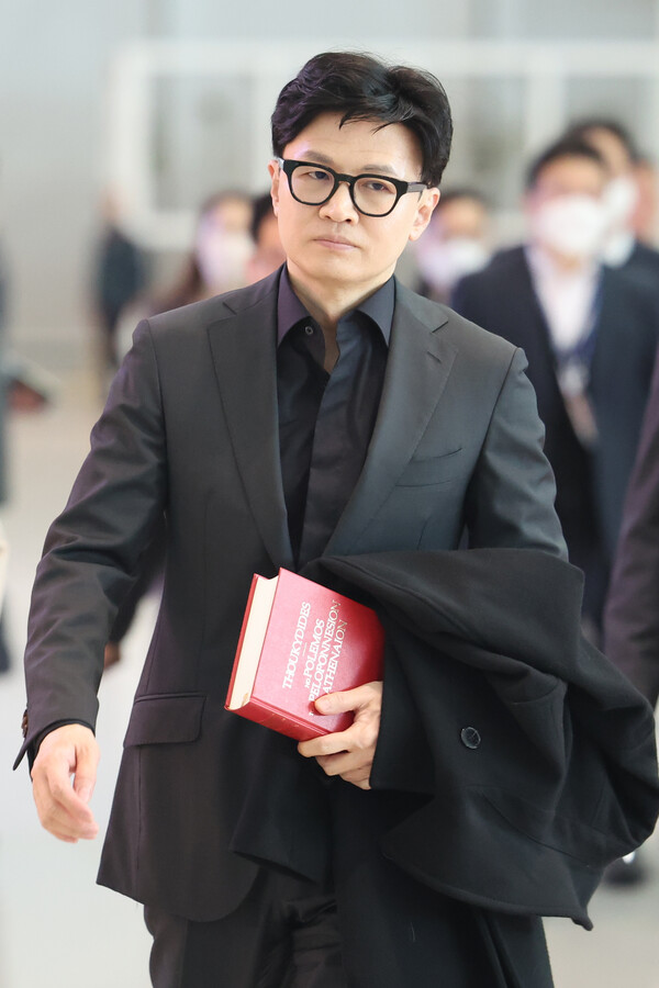 한동훈 법무부 장관이 7일 오전 인천공항을 통해 출입국·이민 정책과 관련한 협력체계를 갖추기 위한 유럽 출장을 가고 있다. 한 장관이 출국장으로 향하며 손에 든 빨간색 책은 2500여 년 전 그리스 역사가 투키디데스가 쓴 펠로폰네소스 전쟁사이다. /연합뉴스