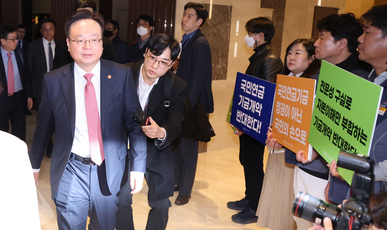 조규홍 보건복지부 장관이 지난 3월 7일 중구 프레지던트 호텔에서 열린 국민연금기금운용위원회에 참석 중인 가운데 공적연금강화국민행동 회원들이 팻말을 들고 시위하고 있다. /연합뉴스