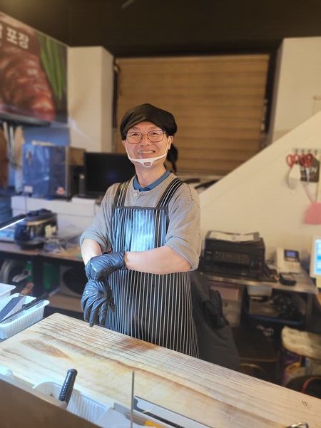 가게 문을 들어서니 제법 족발집 사장다운 포스를 드러내며 칼질을 하고 있었다. 나를 보고 씨익 웃는 모습은 영락없는 동네 청년인데 두건과 앞치마를 두르고 족발을 썰고 있으니 장인의 모습이다. 족발 써는 조리대 앞에 선 신교진 PD /사진=김성주