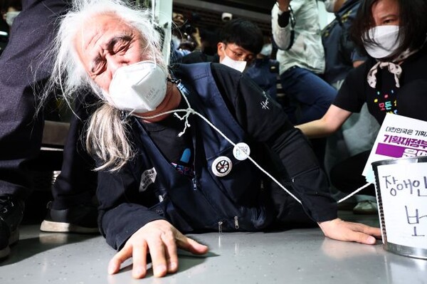 전국장애인철폐연대(전장연) 소속 장애인들이 지난해 5월 3일 오전 서울 지하철 3호선 경복궁역에서 출근길 지하철 탑승 시위를 하고 있다. /연합뉴스