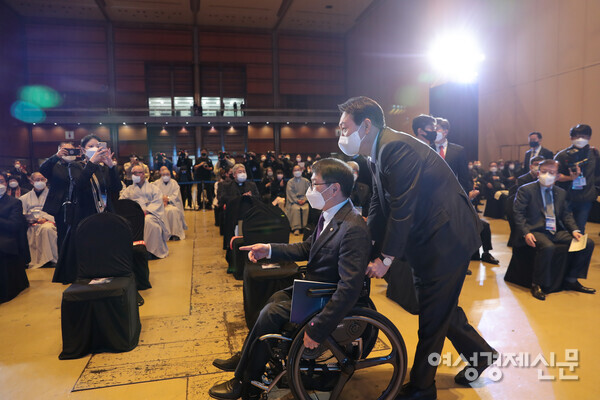 지난 2021년 12월 10일 여성경제신문과 한국노인복지중앙회가 공동 주최한 대통령후보 초청 사회복지비전 선포대회에서 국민의힘 비례대표 이종성 의원의 휠체어를 직접 밀고 입장하는 당시 윤석열 국민의힘 대통령 후보. /여성경제신문