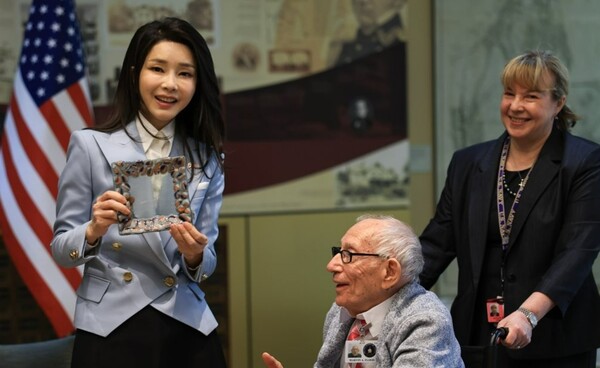 미국을 국빈 방문한 윤석열 대통령의 부인 김건희 여사가 25일(현지 시각) 워싱턴DC 미 보훈요양원에서 한국전 참전용사인 마빈 플로드 씨가 제작한 유리세공 접시를 선물 받고 있다. /연합뉴스