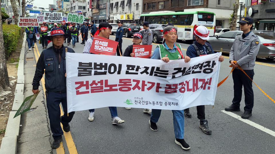 민주노총 전국건설노동조합 충북지부 조합원들이 1일 노동절 대회에 앞서 사전집회를 연 뒤 충북도청 앞을 행진하고 있다. /연합뉴스