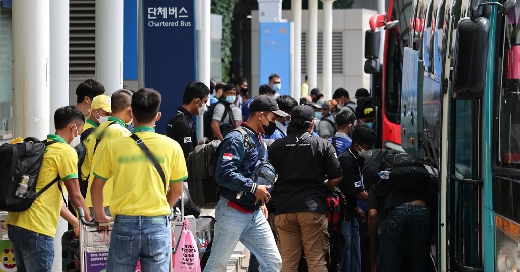 인천국제공항에서 단체 버스를 타는 외국인 노동자들 /연합뉴스
