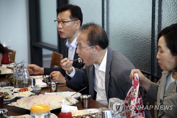 국민의힘 윤재옥 원내대표가 23일 오후 서울 송파구 가락수산시장을 방문해 수산물을 먹고 있다. /연합뉴스