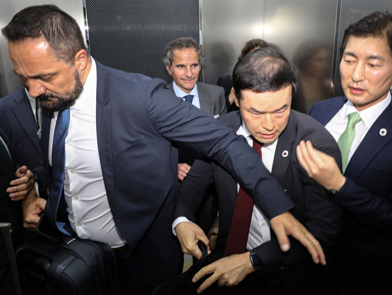 북한이 중국에 이어 국제원자력기구(IAEA) 보고서를 향해 맹비난했다. 사진은 라파엘 그로시 국제원자력기구 사무총장(사진 가운데)이 지난 7일 밤 서울 강서구 김포공항 국제선에 도착해 시민단체의 항의를 피해 다른 곳으로 이동하고 있는 모습. /연합뉴스