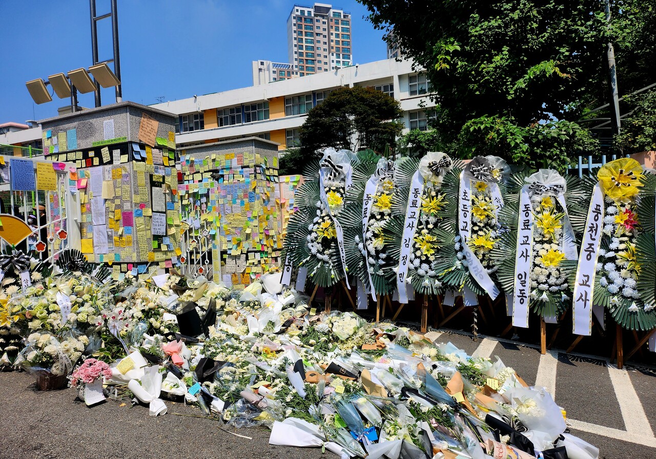 서울 서초구 서이초등학교 정문을 장식한 추모 꽃다발과 화한. 벽면은 A씨를 추모하는 포스트잇으로 가득채워져 있다. /이상헌 기자