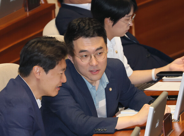 무소속 김남국 의원이 지난달 30일 국회에서 열린 본회의에서 민주당 이탄희 의원과 대화하고 있다. /연합뉴스