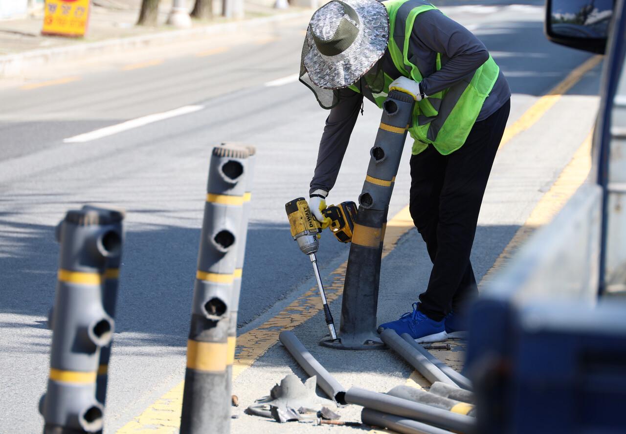 3일 대구 낮 기온이 37.7도까지 치솟은 가운데 수성구 파동행정복지센터 앞 도로에 설치된 중앙분리대가 열기를 견디지 못하고 쓰려지면서 관할 수성구가 이 일대 나머지 중앙분리대를 사전에 철거하고 있다. /연합뉴스