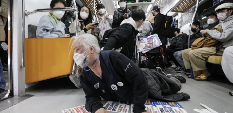 박경석 전국장애인차별철폐연대(전장연) 상임공동대표가 지난해 4월 21일 서울지하철 3호선 경복궁역 열차에서 장애인 권리예산 확보 및 이동권 보장을 촉구하며 오체투지 시위를 하고 있다. /연합뉴스