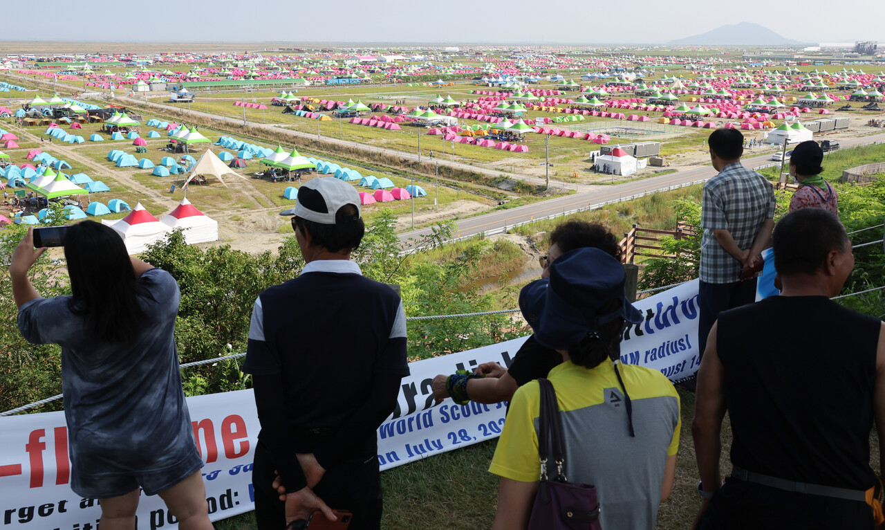 뜨거운 태양광에 노출된 2023 새만금 세계스카우트잼버리 야영장을 시민들이 바라보고 있다. /연합뉴스