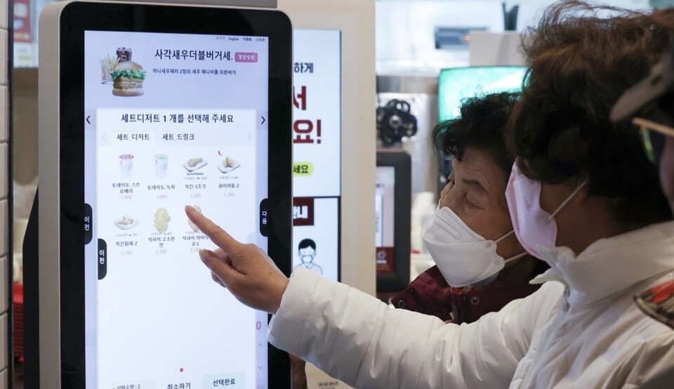 햄버거 가게에서 고령자들이 키오스크를 통해 햄버거를 주문하고 있다. /연합뉴스