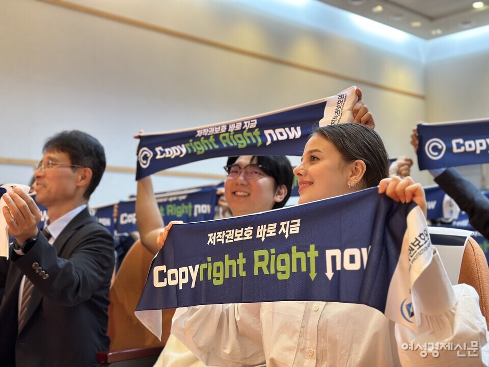 저작권 보호 대국민 캠페인 선포식에서 저작권 보호 현수막을 들고 웃고 있는 크리에이터 준오브다샤 부부. /김현우 기자