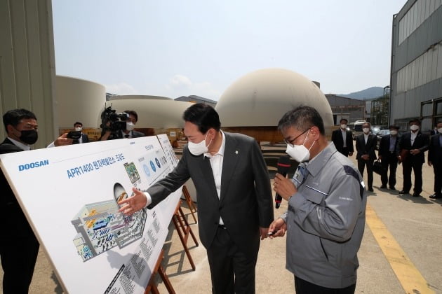 윤석열 대통령이 지난 6월 22일 경남 창원 두산에너빌리티 원자력 공장을 방문해 김종두 전무의 안내를 받으며 APR1400 원자력 발전소 조감도를 살펴보고 있다. /연합뉴스