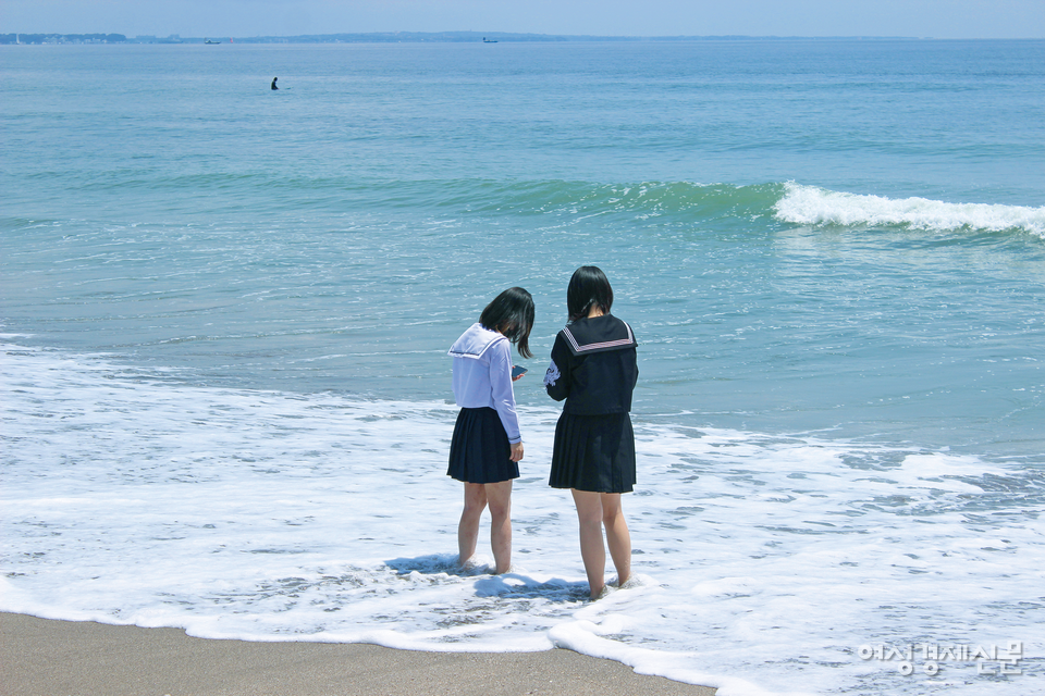 슬램덩크 팬이라 밝힌 일본인 여학생 두 명이 기찻길 앞 바닷가를 거닐고 있다. /안혜인