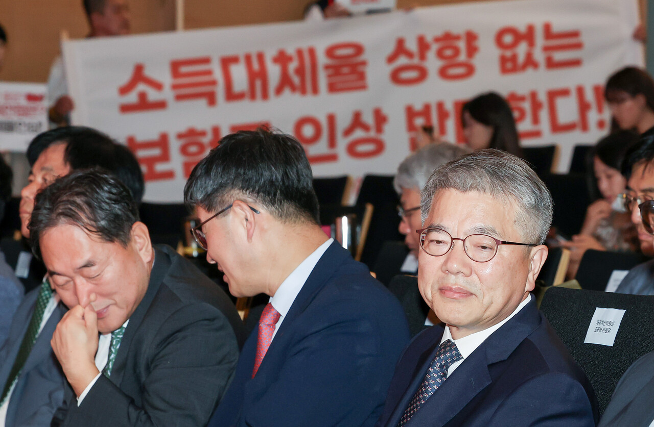 재정계산위는 초안에 없던 소득대체율 45%와 50% 인상안을 최종보고서에 넣기로 지난 13일 회의에서 결정했다. 사진은 지난 9월 1일 국민연금 재정계산위원회 공청회에 참석한 김용하 위원장(오른쪽)과 현수막을 들고 있는 공적연금강화국민운동(연금행동) 관계자들 /연합뉴스