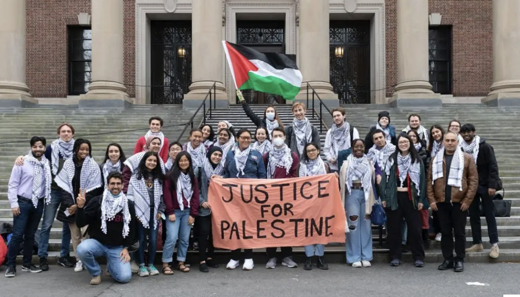 하버드대 재학생들이 '팔레스타인의 정의를 위해'라는 문구가 적힌 플래카드 앞에서 기념 촬영을 하고 있다. /AP=연합뉴스