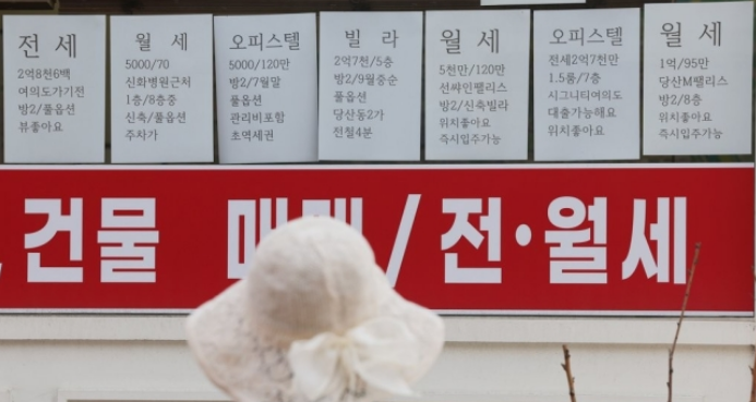 공인중개사에 붙은 임대차 매물 안내를 한 시민이 바라보고 있다. /연합뉴스