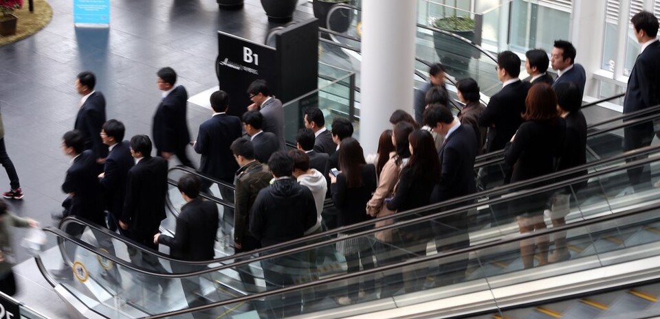 서울 시내 한 빌딩에서 직장인들이 이야기를 나누며 점심을 위해 외출하고 있다. /연합뉴스
