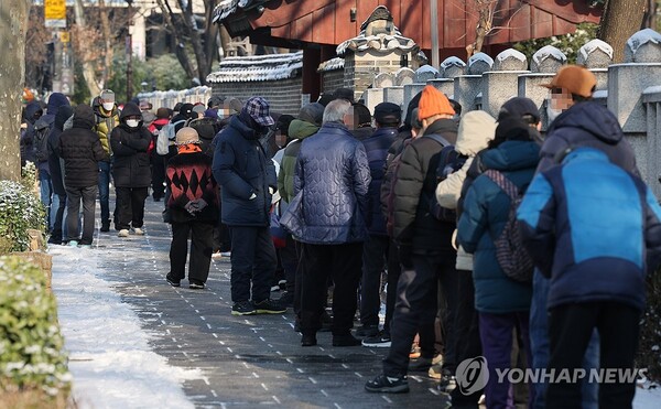 크리스마스이브인 24일 오전 서울 종로구 탑골공원 인근에서 노인들이 무료 급식을 위해 길게 줄을 서 기다리고 있다. /연합뉴스