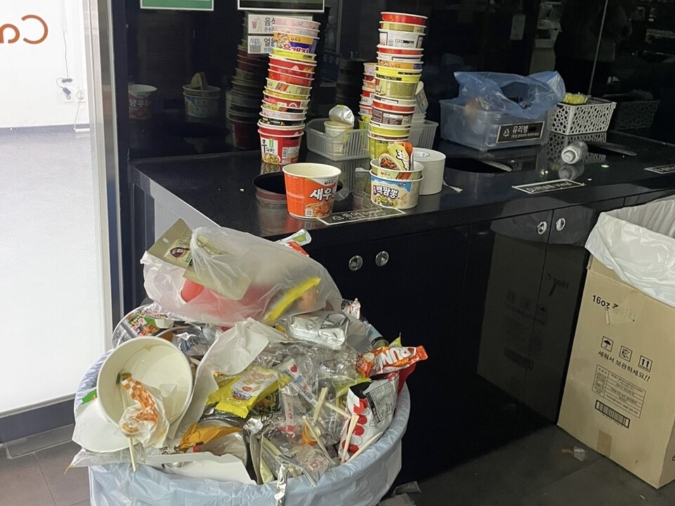 다 먹은 컵라면 용기들이 위태위태하게 쌓여 있다. 결국 큰 소리를 내며 컵라면 용기들이 쓰러졌다. 새벽 시간, 이를 치우는 이는 아무도 없었다. /강윤지