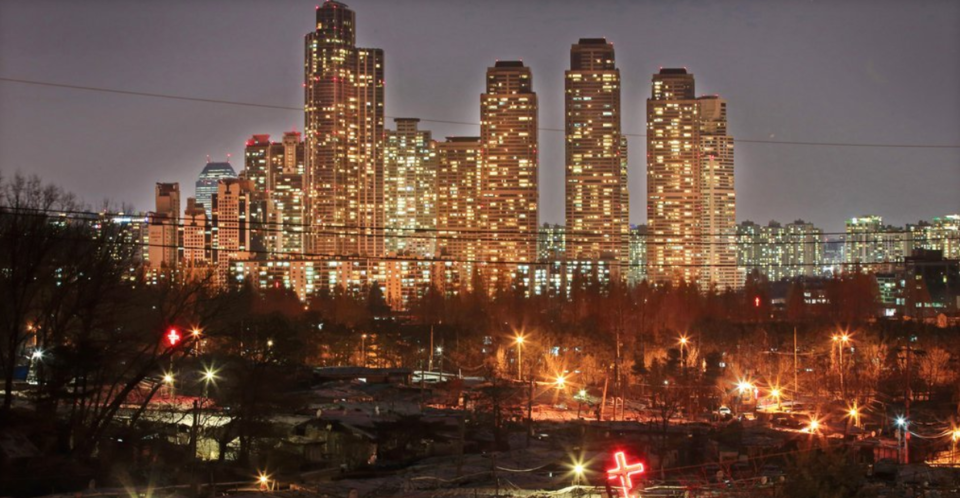 서울 구룡마을 판자촌 뒤로 화려한 불빛의 도곡동 타워팰리스가 보인다. /연합뉴스