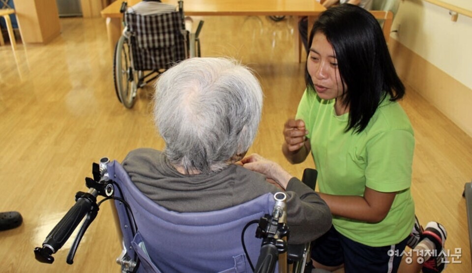일본 오사카시 기타구에 위치한 한 노인요양시설에서 입소자와 대화중인 외국인 개호복지사(요양보호사). /여성경제신문