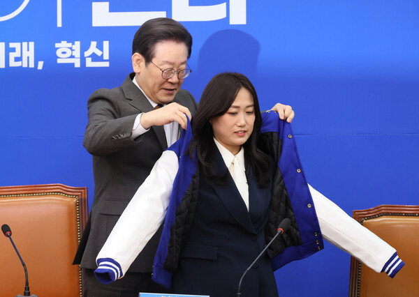더불어민주당 이재명 대표가 29일 국회에서 열린 11·12차 인재영입식에서 백승아 전 교사에게 당 점퍼를 입혀주고 있다. /연합뉴스