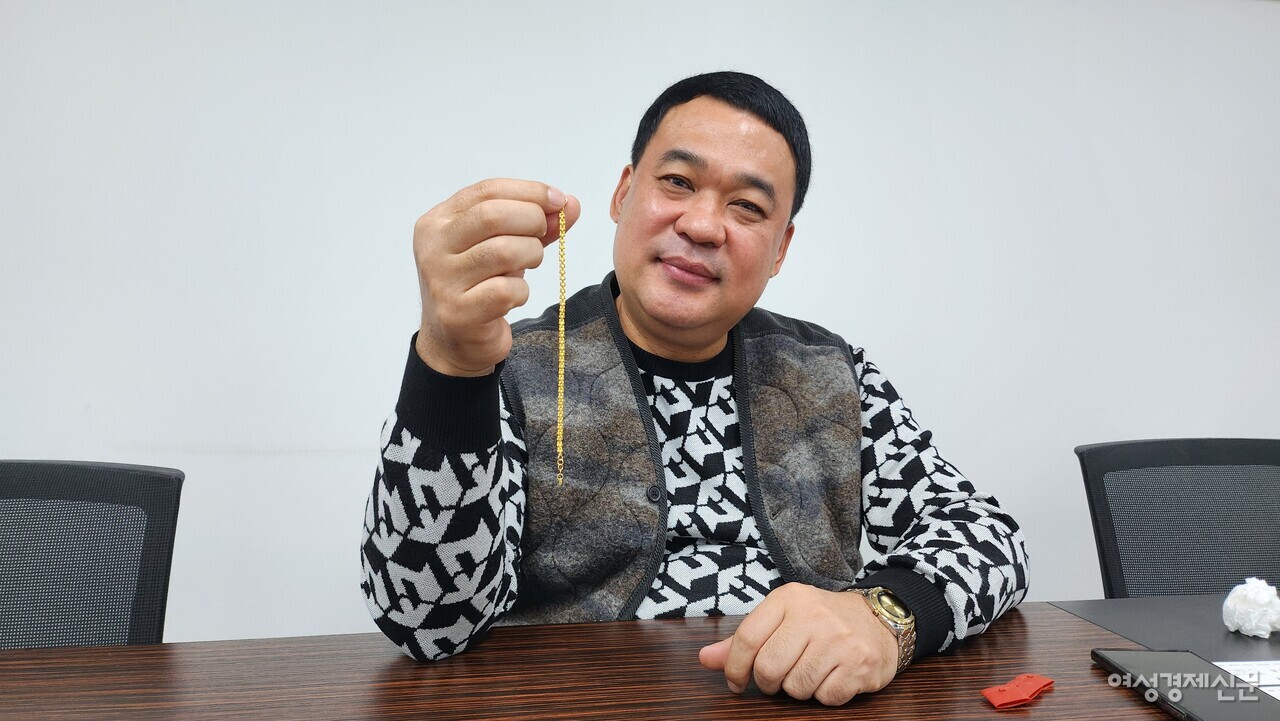 조태호 한국금시장그룹 대표가 지난 22일 서울 종로구에 위치한 한국금시장그룹 사무실에서 금형 프레스로 이날 처음 생산에 성공한 1돈짜리 금팔찌를 들어 보이고 있다. 팔찌 줄의 속을 비게 만들어 중량에 비해 훨씬 부피를 늘린 게 특징이다./류빈 기자