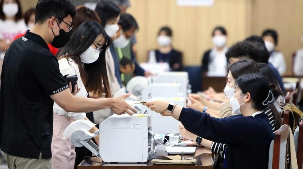 제8회 전국동시지방선거 사전투표 첫날인 지난 2022년 5월 27일 오전 제주도의회에 마련된 투표소에서 유권자들이 투표지를 받고 있다. /연합뉴스