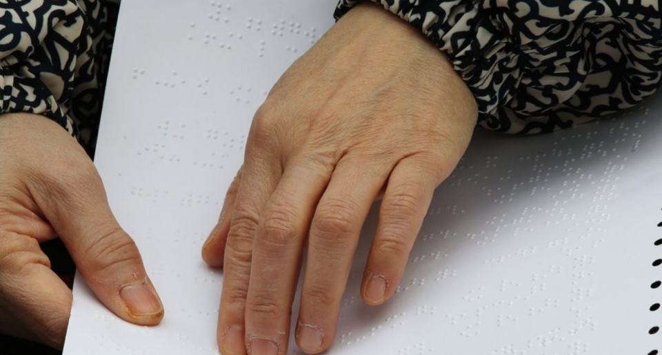 지난 2019년 서울 양천구 목동 한국방송회관 앞에서 열린 사단법인 대한안마사협회 불법 마사지 인터넷광고 차단촉구 결의대회에서 한 참가자가 점자로 인쇄된 호소문을 읽고 있다. /연합뉴스