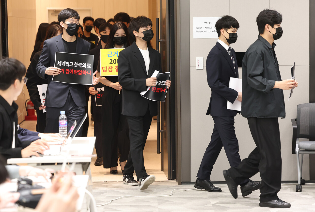 전공의들이 15일 오전 서울 용산구 대한의사협회에서 열린 '정책피해 전공의, 박민수 복지부 제2차관 직권남용 및 권리행사방해 혐의 집단고소 기자회견'에서 검은 옷을 입은 채로 손팻말을 들고 입장하고 있다. /연합뉴스