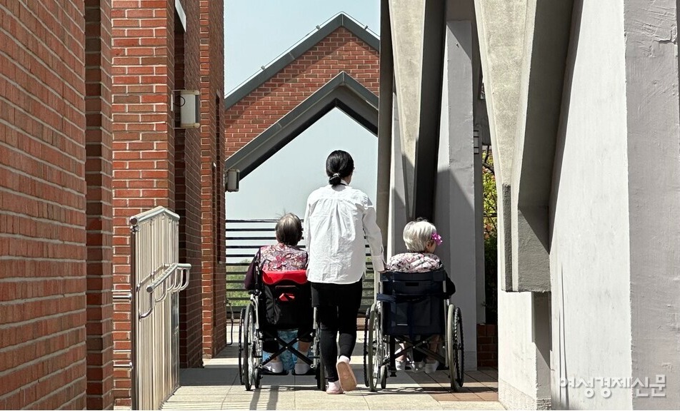 휠체어를 탄 두 어르신이 옥상 정원에서 점심 식사 후 산책하고 있다. /김정수 기자