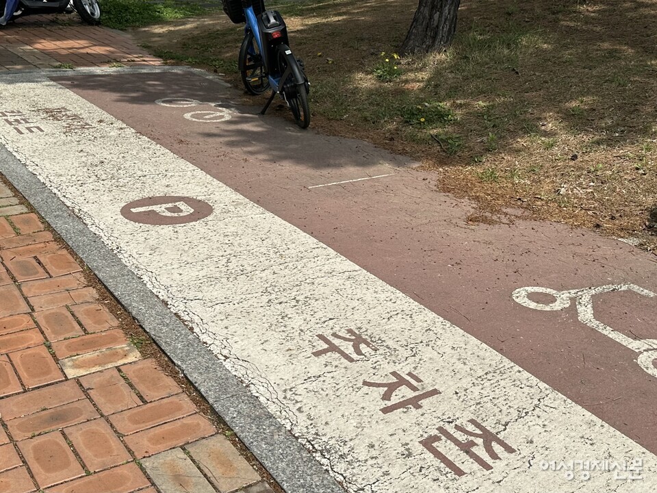 김포시 내 점자블록 위 주차된 전동킥보드 근처에 위치한 자전거‧킥보드 전용 주차 공간. 자전거 한 대만 주차돼 있다. /김정수 기자