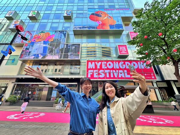 롯데백화점은 26일부터 오는 5월 6일까지 서울시·중구청과 함께 ‘2024 명동 페스티벌’을 연다.  캐릭터와 서울색으로 장식된 명동길에서 사진을 촬영하는 모습 /롯데백화점