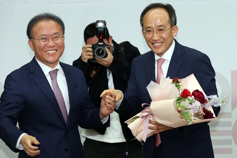 국민의힘 추경호 신임 원내대표가 9일 국회에서 열린 제22대 원내대표 선출 당선자총회에서 당선 확정 후 꽃다발을 들고 윤재옥 전 원내대표와 함께 기념촬영을 하고 있다. /연합뉴스