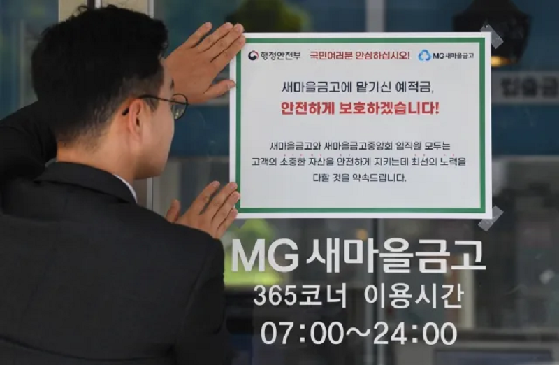 지난해 7월 새마을금고 직원이 예금자보호 공고문을 붙이고 있다. /연합뉴스