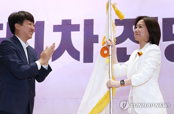 19일 국회 의원회관에서 열린 개혁신당 전당대회에서 신임 당 대표로 선출된 허은아 후보가 이준석 대표로부터 당기를 건네받고 있다. /연합뉴스