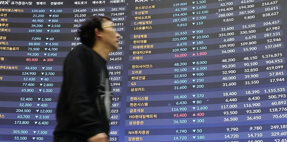  지난 1월 17일 서울 여의도 한국거래소 홍보관에서 한 시민이 전광판 앞을 지나가고 있다. /연합뉴스