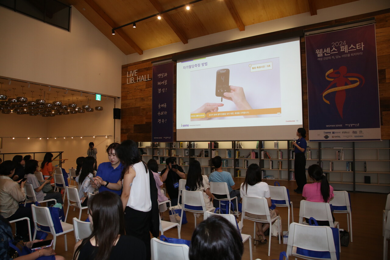여성경제신문과 우먼센스가 공동으로 개최한 '2024 웰센스 페스타' 참석자들이 실시간 혈당 체크 기기를 시험 착용하고 있다. /류빈 기자 