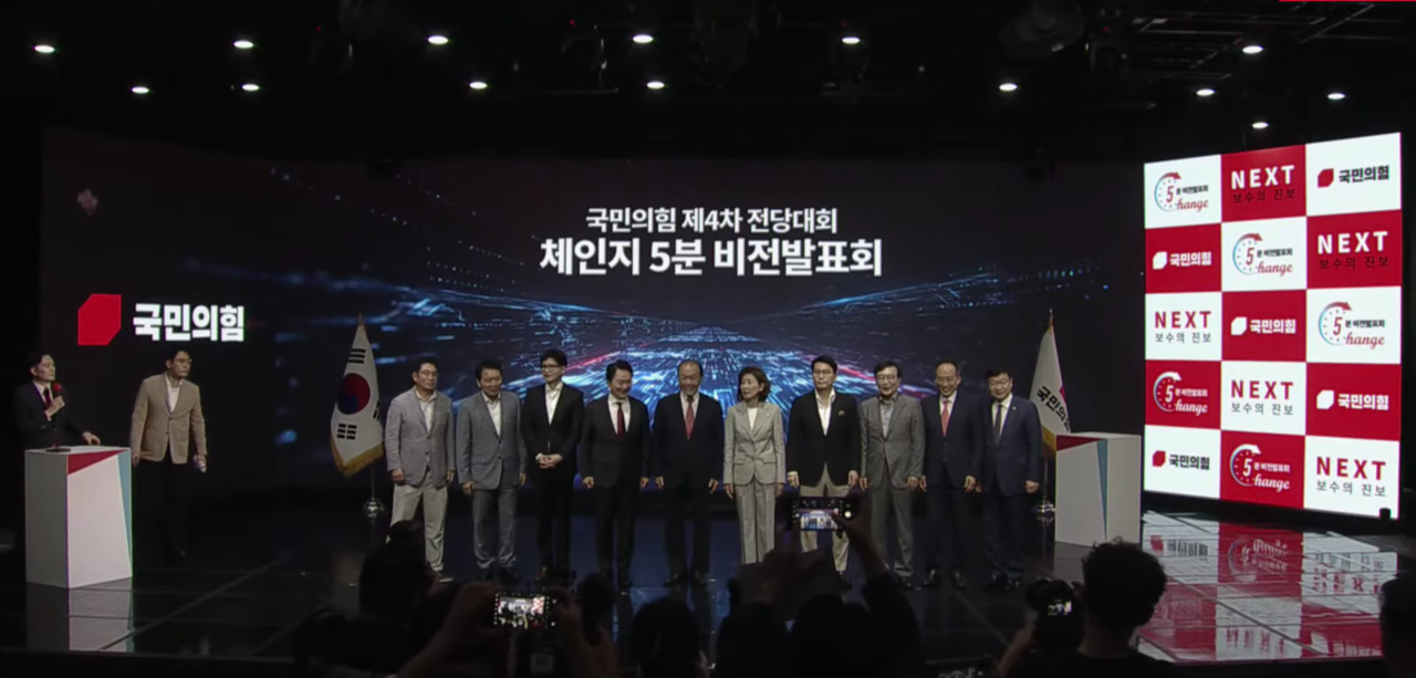국민의힘 전당대회 출마자들이 기념사진을 준비하는 무대 오른편 넥스트 보수의 진보란 슬로건이 배경 화면으로 보인다.