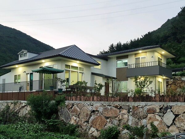 필자 설계 경남 양산 심한재, 사랑채 개념의 거실채와 안채 격인 침실채가 계단홀로 분리되어 있다. 침실채의 1층은 주인 부부의 영역이며 이층은 자식들의 영역으로 손님이 오면 객실로 쓰게 될 것이다. 거실채는 계단실의 중간으로 연결되어 침실채의 가운데 있는 셈이다. 손님과 밤새워 회포를 풀어도 다른 식구들의 생활에 지장을 주지 않는다. /사진=김정관