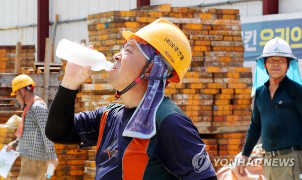 광주 북구 오치동 한 공사 현장에서 작업자들이 더위를 식히기 위해 생수를 마시고 있다. /연합뉴스