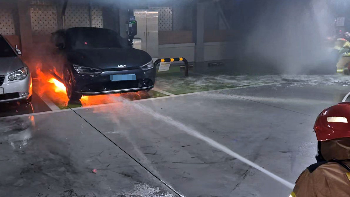 지난 6일 오전 5시께 충남 금산군 금산읍의 한 주차타워 1층에 주차 중이던 전기차 밑에서 불이나 소방대원들이 불을 끄고 있다. /충남 금산소방서