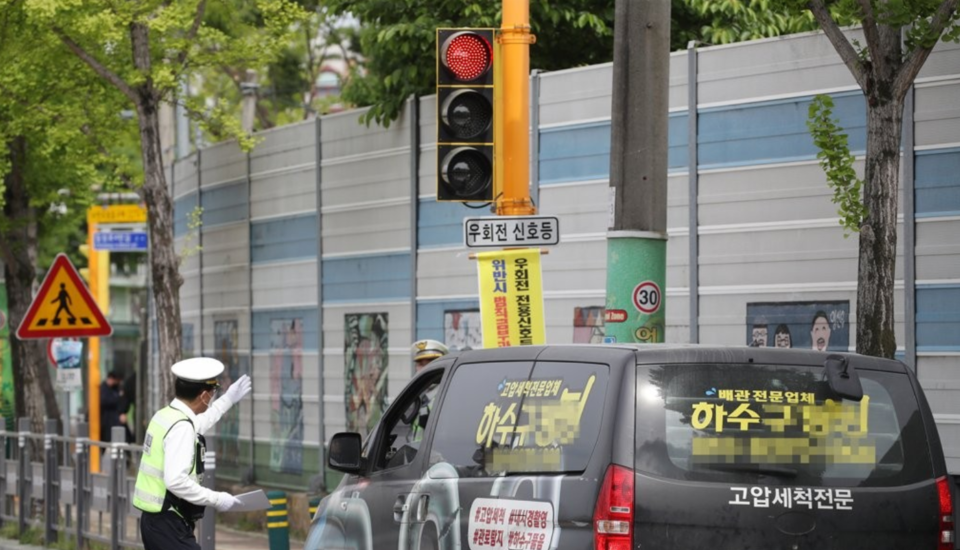 우회전 신호등 법규를 지키지 않은 차량이 교통경찰에 단속되는 모습 /연합뉴스