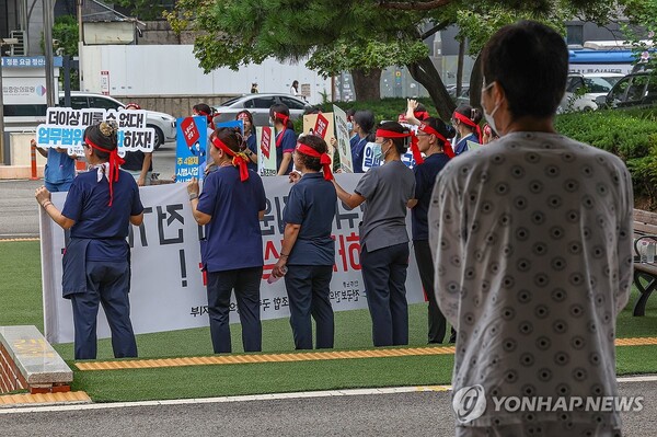 전국민주노동조합총연맹 전국보건의료산업노동조합 국립중앙의료원지부가 26일 오전 서울 중구 서울국립중앙의료원에서 진료 정상화, 불법진료 근절, 처우 개선을 촉구하는 출근길 선전전을 열자 한 환자가 이를 지켜보고 있다. /연합뉴스