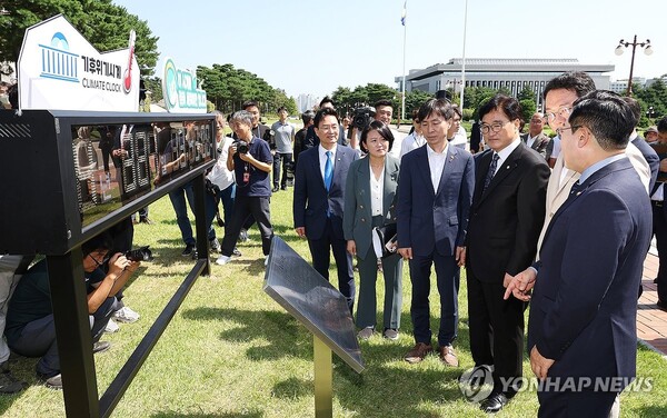 우원식 국회의장을 비롯한 여야 원내대표 및 참석자들이 4일 오전 국회에서 '기후위기시계' 이전 제막식을 마친 뒤 시계를 살펴보고 있다. /연합뉴스