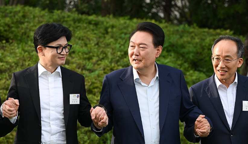 윤석열 대통령이 지난 7월 24일 서울 용산 대통령실 앞 파인그라스에서 열린 국민의힘 신임 지도부 만찬에서 한동훈 대표(왼쪽), 추경호 원내대표(오른쪽) 등과 함께 손을 맞잡고 기념 촬영을 하고 있다. /연합뉴스