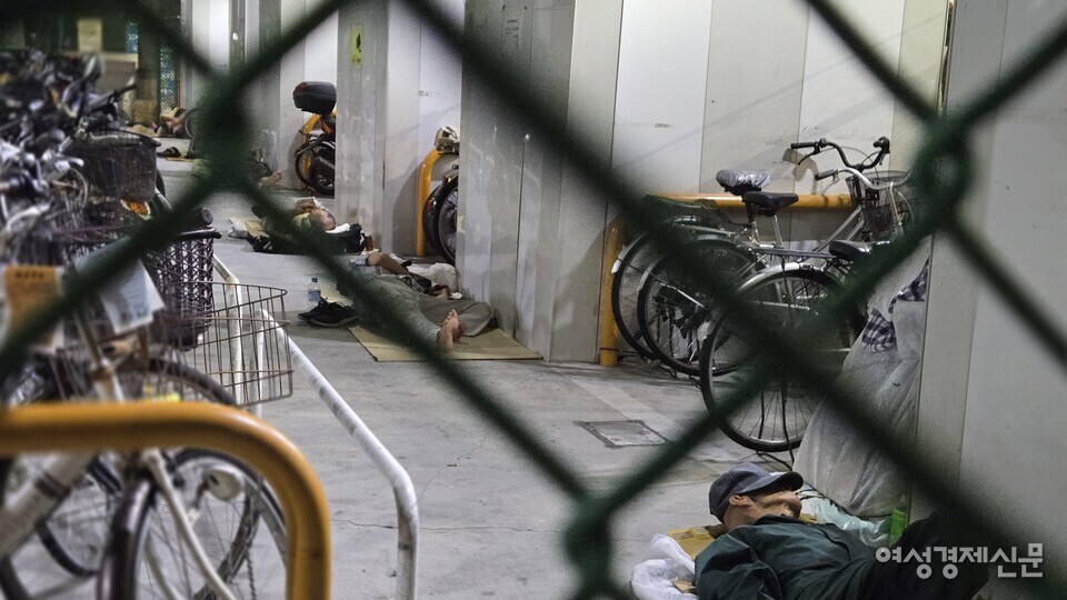 13일 오사카 아이린지구에 위치한 한 자전거 주차장에 노숙인들이 누워 잠을 청하고 있다. /오사카=김현우 기자